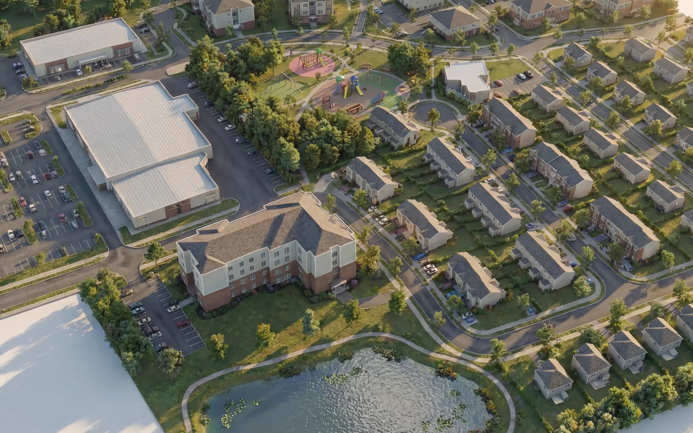 Réserve Étoilée 社区(East Angus)概念鸟瞰图:联排别墅、双拼住宅、多户住宅楼、公园与水塘。